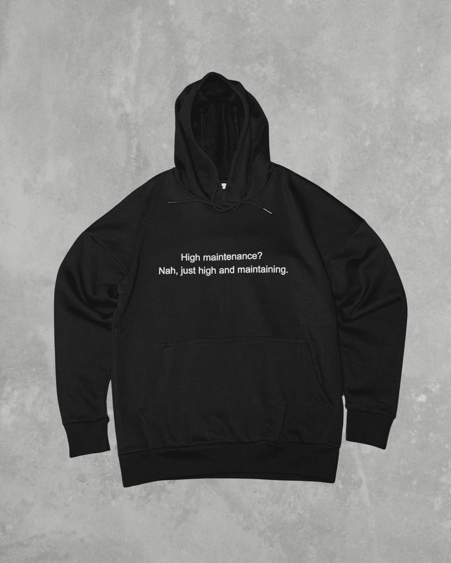 Black heavyweight hoodie with front text 'High maintenance? Nah, just high and maintaining' – 400 GSM thick premium streetwear hoodie for men and women.