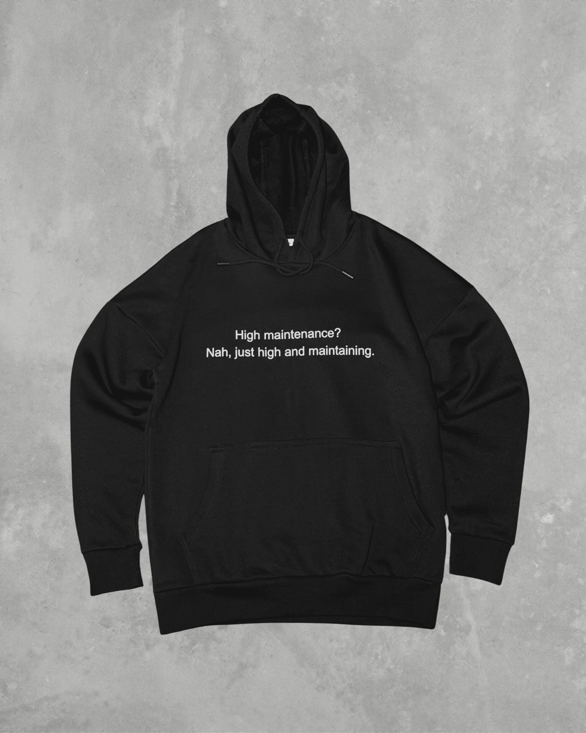 Black heavyweight hoodie with front text 'High maintenance? Nah, just high and maintaining' – 400 GSM thick premium streetwear hoodie for men and women.