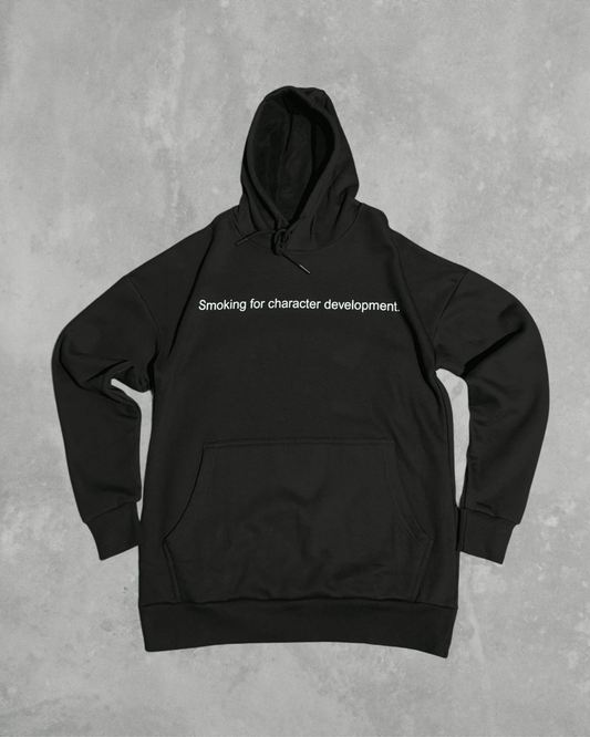 Black heavyweight hoodie with front text 'Smoking for character development' – 400 GSM thick premium streetwear hoodie for men and women.