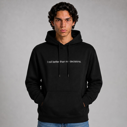 A close up shot of a person wearing a black thick hoodie with text 'I roll better than my decisions'  with 400 GSM premium streetwear hoodie for men and women and blue jeans on a gray background.