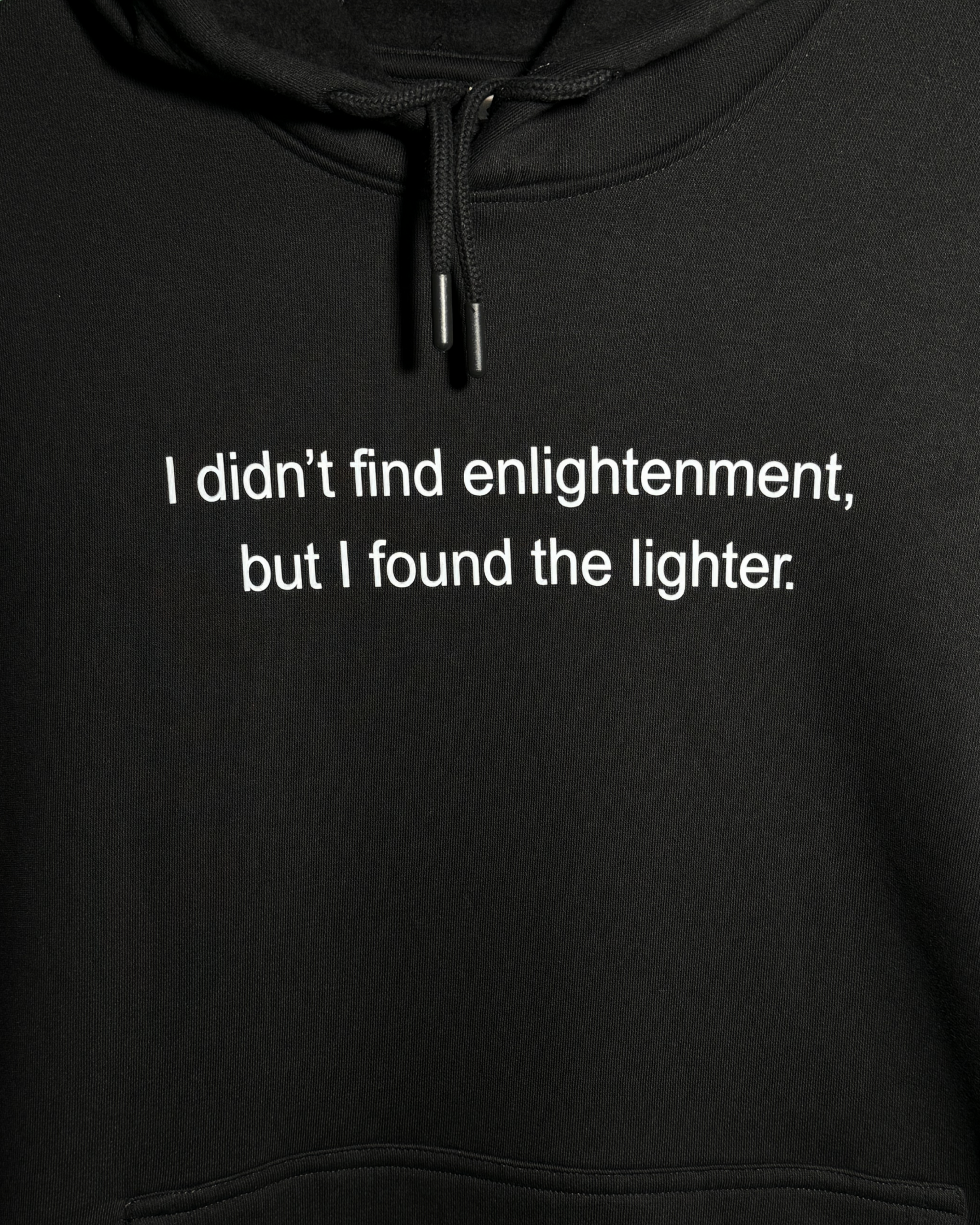 Black heavyweight hoodie with front text 'I didn't find enlightenment, but I found the lighter' – 400 GSM thick premium streetwear hoodie for men and women - Zoomed in.
