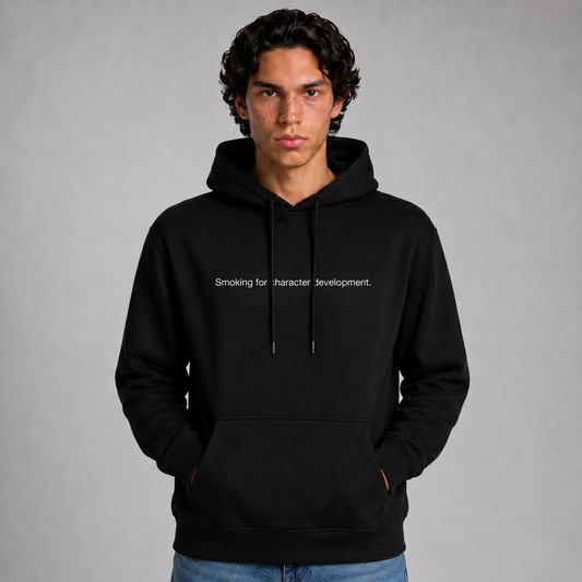 A close up shot of a person wearing a black thick hoodie with text 'Smoking for character development' with 400 GSM premium streetwear hoodie for men and women and blue jeans on a gray background.